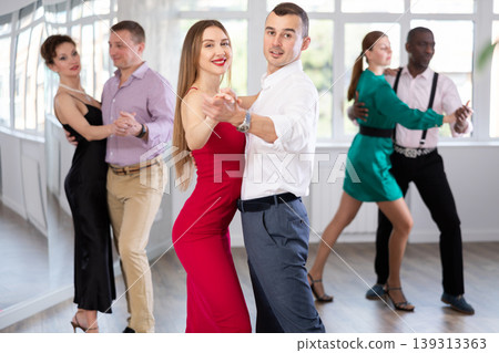 Young man and woman practicing waltz in dancing studio Young man and woman practicing waltz in dancing studio 139313363