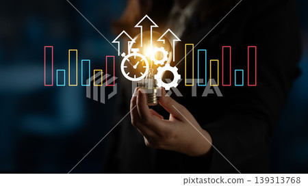 Businessperson Holding Light Bulb with Gears and Upward Arrows Representation of Innovation and Growth in a Corporate Environment Ledger Businessperson Holding Light Bulb with Gears and Upward Arrows Representation of Innovation and Growth in a Corporate Environment Ledger 139313768