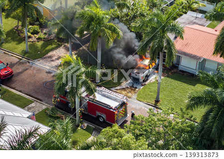 Firefighters extinguishing burning car on residential street in Punta Gorda in Florida Firefighters extinguishing burning car on residential street in Punta Gorda in Florida 139313873