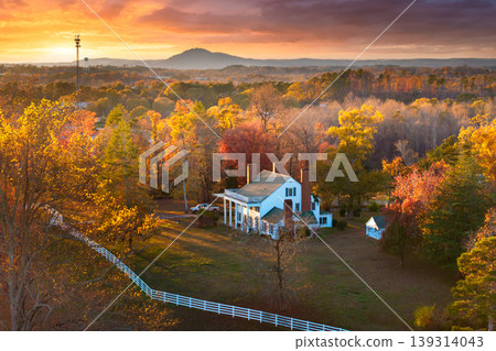 Country-style homes on Tennessee hills surrounded by yellow autumn trees, evening sunlight enhancing vibrant seasonal scenery. 139314043