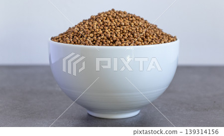 Coriander Seeds Bowl front view Neutral background with negative space to add captions Coriander Seeds Bowl front view Neutral background with negative space to add captions 139314156