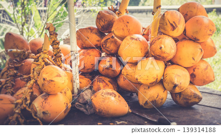 King coconut bunch on a table with a knife King coconut bunch on a table with a knife 139314188