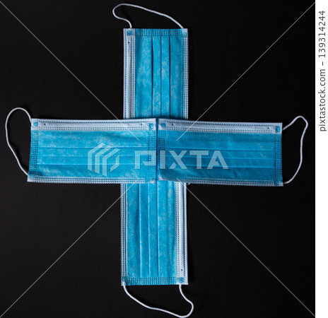 Four surgical face masks put together as a cross in black background Four surgical face masks put together as a cross in black background 139314244