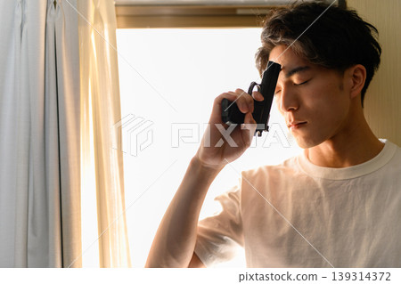 A man holds a gun to his forehead. A man holds a gun to his forehead. 139314372