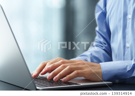 Business person using laptop at office desk. Close up of hands and keyboard. Business person using laptop at office desk. Close up of hands and keyboard. 139314914