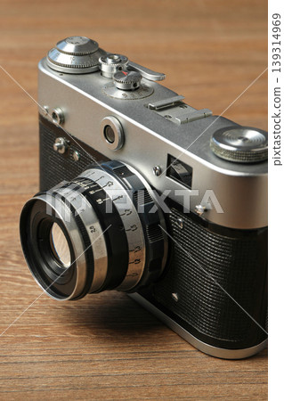A vintage camera rests on a wooden table 139314969