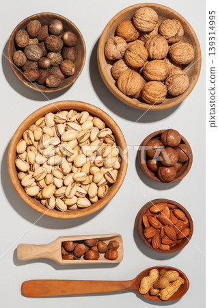 Nuts in wooden bowls on a gray background 139314995