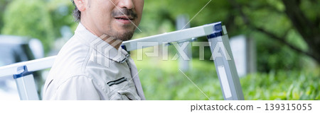 一名工人扛著梯子前往植樹或工地進行施工管理工作的肖像照片；橫幅圖片，但沒有臉部。 139315055