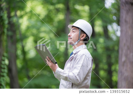 林業和建築管理領域的現場工作人員戴著安全帽，使用平板電腦進行檢查，示範安全管理和數位化操作。 139315652