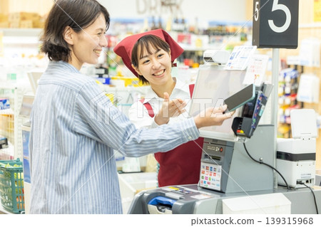 一個女人在一家超市收銀台付款 139315968