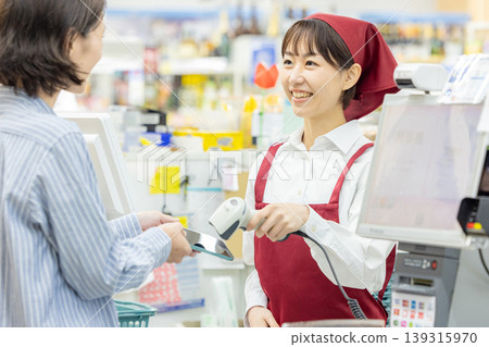 A woman paying at a supermarket cashier A woman paying at a supermarket cashier 139315970