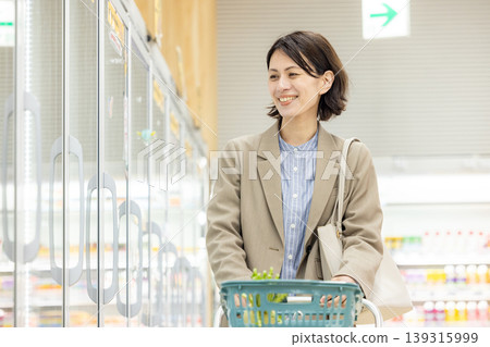 A woman shopping at the supermarket on her way home from work 139315999