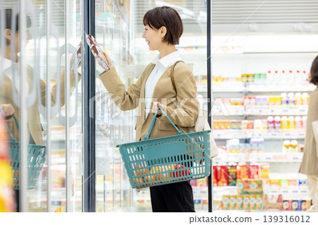 A woman shopping at the supermarket on her way home from work A woman shopping at the supermarket on her way home from work 139316012