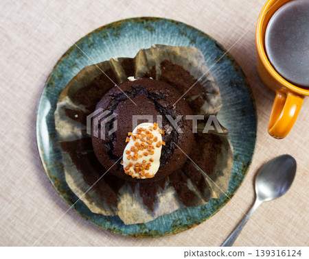 Chocolate tulip muffin topped with cream and caramel sprinkles Chocolate tulip muffin topped with cream and caramel sprinkles 139316124