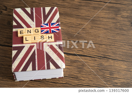 Word English on book with United Kingdom flag, learning English language courses concept. Word English on book with United Kingdom flag, learning English language courses concept. 139317600