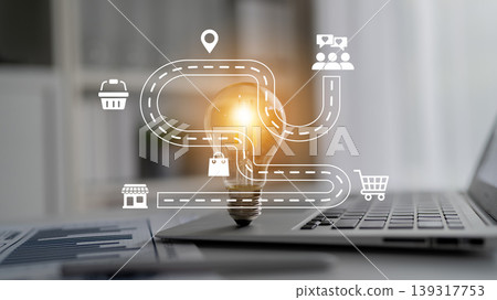 Conceptual Image of Path to Success with Light Bulb Representing Ideas and Icons for Business, Marketplace, and Technology on Laptop Ledger 139317753