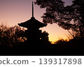 一座三層寶塔矗立在粉紅色的暮色天空下。 139317898