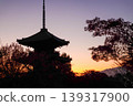 一座三層寶塔矗立在粉紅色的暮色天空下。 139317900