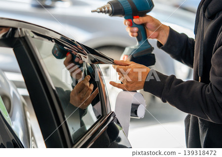 A car wrapping specialist applies a polyurethane film to the car. Detailer PPF 139318472