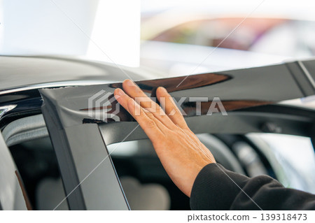 A car wrapping specialist applies a polyurethane film to the car. Detailer PPF 139318473