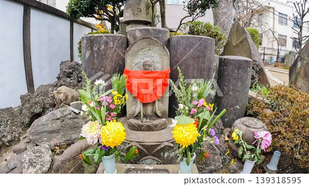 A Jizo statue and colorful floral offerings at Chomeiji Temple in Tokyo. A Jizo statue and colorful floral offerings at Chomeiji Temple in Tokyo. 139318595