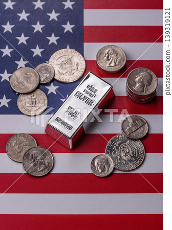 A silver bar, white metal against a backdrop of USA flag, as a concept. A silver bar A silver bar, white metal against a backdrop of USA flag, as a concept. A silver bar 139319121