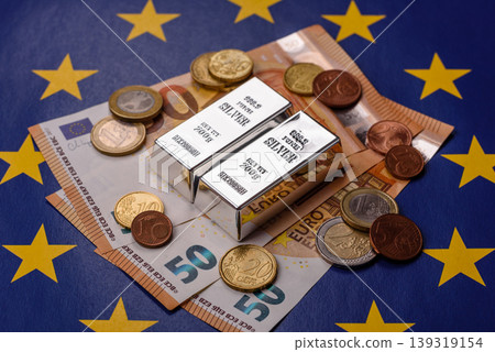 A silver bar, white metal against a backdrop of EU flag, as a concept. A silver bar A silver bar, white metal against a backdrop of EU flag, as a concept. A silver bar 139319154