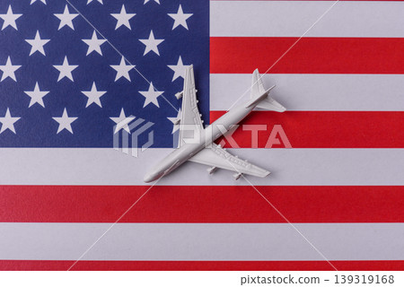 An airplane on the US flag as a conceptual backdrop for flights and travel. An airplane on the flag An airplane on the US flag as a conceptual backdrop for flights and travel. An airplane on the flag 139319168