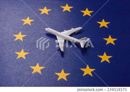 An airplane on the EU flag as a conceptual backdrop for flights and travel. An airplane on the flag An airplane on the EU flag as a conceptual backdrop for flights and travel. An airplane on the flag 139319171