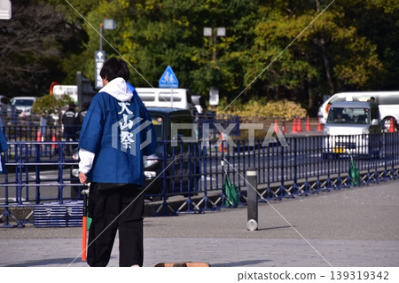 在愛知縣犬山市舉行的犬山春季祭典上，一名男子身穿一件背後寫著「犬山祭」字樣的法被，站在廣場上。 139319342