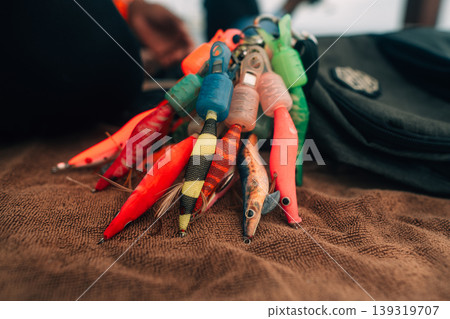 Close-up of a colorful artificial fishing lure with sharp treble hooks. Close-up of a colorful artificial fishing lure with sharp treble hooks. 139319707