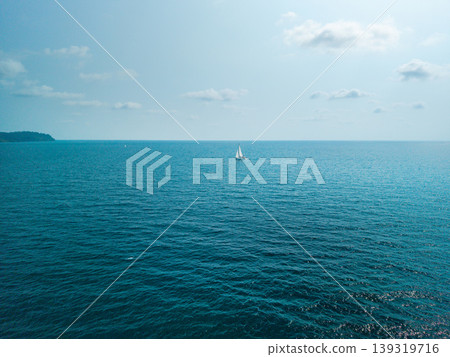 Minimalist seascape with a white sailboat in the middle of the deep blue ocean, Thailand Minimalist seascape with a white sailboat in the middle of the deep blue ocean, Thailand 139319716