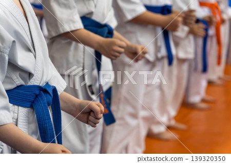Children in white karate gi with blue and orange belts Children in white karate gi with blue and orange belts 139320350