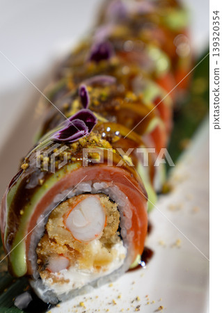 Gourmet sushi roll featuring shrimp tempura, salmon, avocado, and unagi sauce. Gourmet sushi roll featuring shrimp tempura, salmon, avocado, and unagi sauce. 139320354