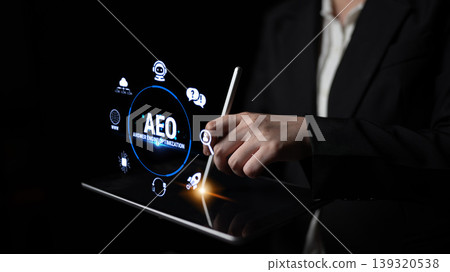 Business professional using digital tablet for data visualization and application development with modern user interface elements and icons in dark setting Fluxor 139320538