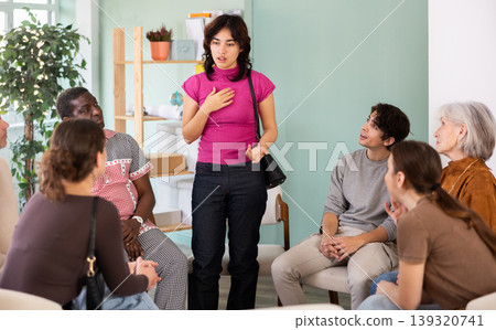Female pedagogue discussing some issues with a group of colleague around table in training room Female pedagogue discussing some issues with a group of colleague around table in training room 139320741
