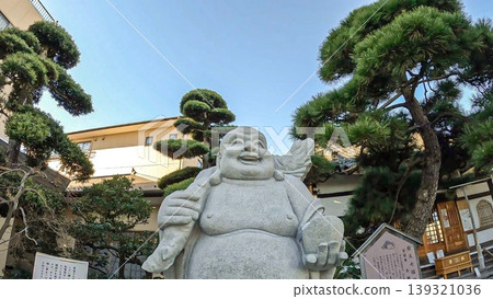 The stone statue of Hotei (the god of happiness and good fortune) at Ryokanji Temple, one of the Shibamata Seven Lucky Gods in Tokyo. The stone statue of Hotei (the god of happiness and good fortune) at Ryokanji Temple, one of the Shibamata Seven Lucky Gods in Tokyo. 139321036