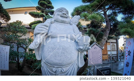 The stone statue of Hotei (the god of happiness and good fortune) at Ryokanji Temple, one of the Shibamata Seven Lucky Gods in Tokyo. The stone statue of Hotei (the god of happiness and good fortune) at Ryokanji Temple, one of the Shibamata Seven Lucky Gods in Tokyo. 139321040
