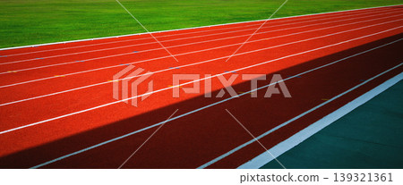 Red running track curves gently through green field Red running track curves gently through green field 139321361