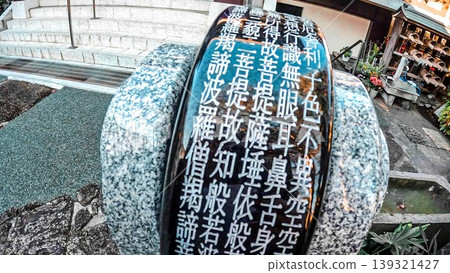 A scene from a temple in Tokyo, featuring the Heart Sutra inscribed on a prayer wheel and the temple grounds. A scene from a temple in Tokyo, featuring the Heart Sutra inscribed on a prayer wheel and the temple grounds. 139321427