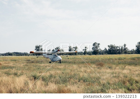 crop duster airplane rolling on dirt runway in open farmland landscape under sunlight with empty space for text panoramic banner scene, agribusiness, aviation, rural economy crop duster airplane rolling on dirt runway in open farmland landscape under sunlight with empty space for text panoramic banner scene, agribusiness, aviation, rural economy 139322213