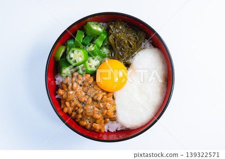 糯米飯碗：米飯上放有納豆、秋葵、山藥泥、海苔和蛋黃（白色背景） 139322571