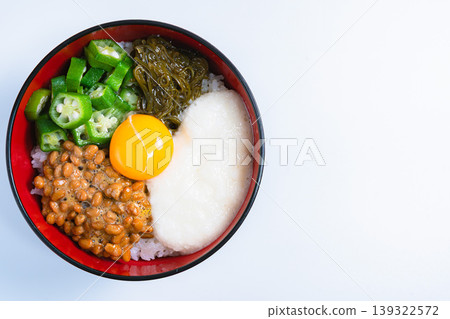 Sticky Rice Bowl: Rice topped with natto, okra, grated yam, mekabu seaweed, and egg yolk (on a white background) Sticky Rice Bowl: Rice topped with natto, okra, grated yam, mekabu seaweed, and egg yolk (on a white background) 139322572