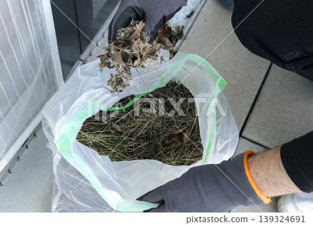Maintenance task of a metal drain grate, focusing on drainage system upkeep and responsible recycling of dry leaves. Maintenance task of a metal drain grate, focusing on drainage system upkeep and responsible recycling of dry leaves. 139324691