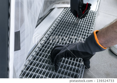 Maintenance task of a metal drain grate, focusing on routine drainage care for use in seasonal maintenance guides. Maintenance task of a metal drain grate, focusing on routine drainage care for use in seasonal maintenance guides. 139324733