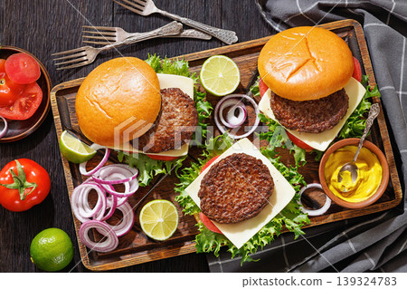 beef cheeseburgers with brioche buns on a tray beef cheeseburgers with brioche buns on a tray 139324783