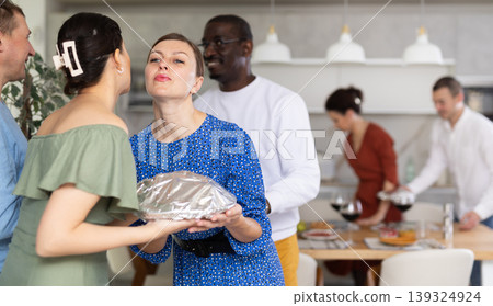 Friends and couples greet each other and give gifts before the festive dinner at house party 139324924