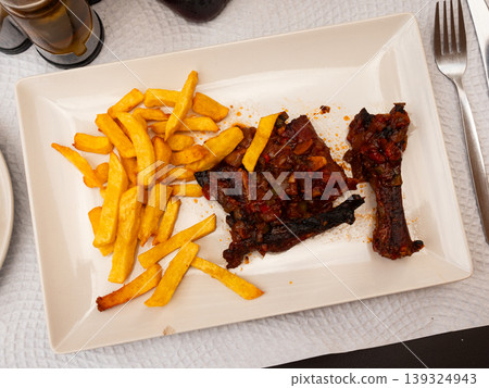 Fried pork ribs served with potatoes on plate Fried pork ribs served with potatoes on plate 139324943