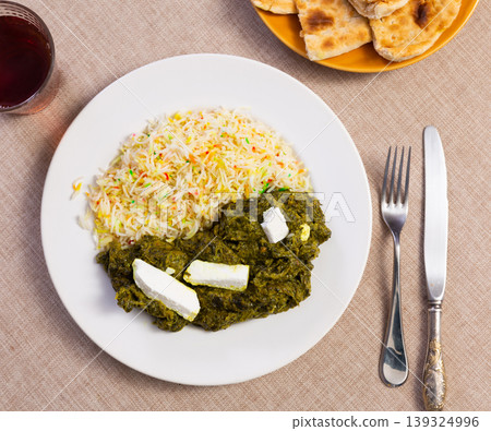 Palak paneer - indian dish consisting of paneer cheese in thick spinach puree with a side of rice Palak paneer - indian dish consisting of paneer cheese in thick spinach puree with a side of rice 139324996