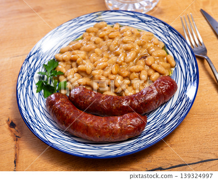 Hot delicious sausages with beans and parsley on plate Hot delicious sausages with beans and parsley on plate 139324997